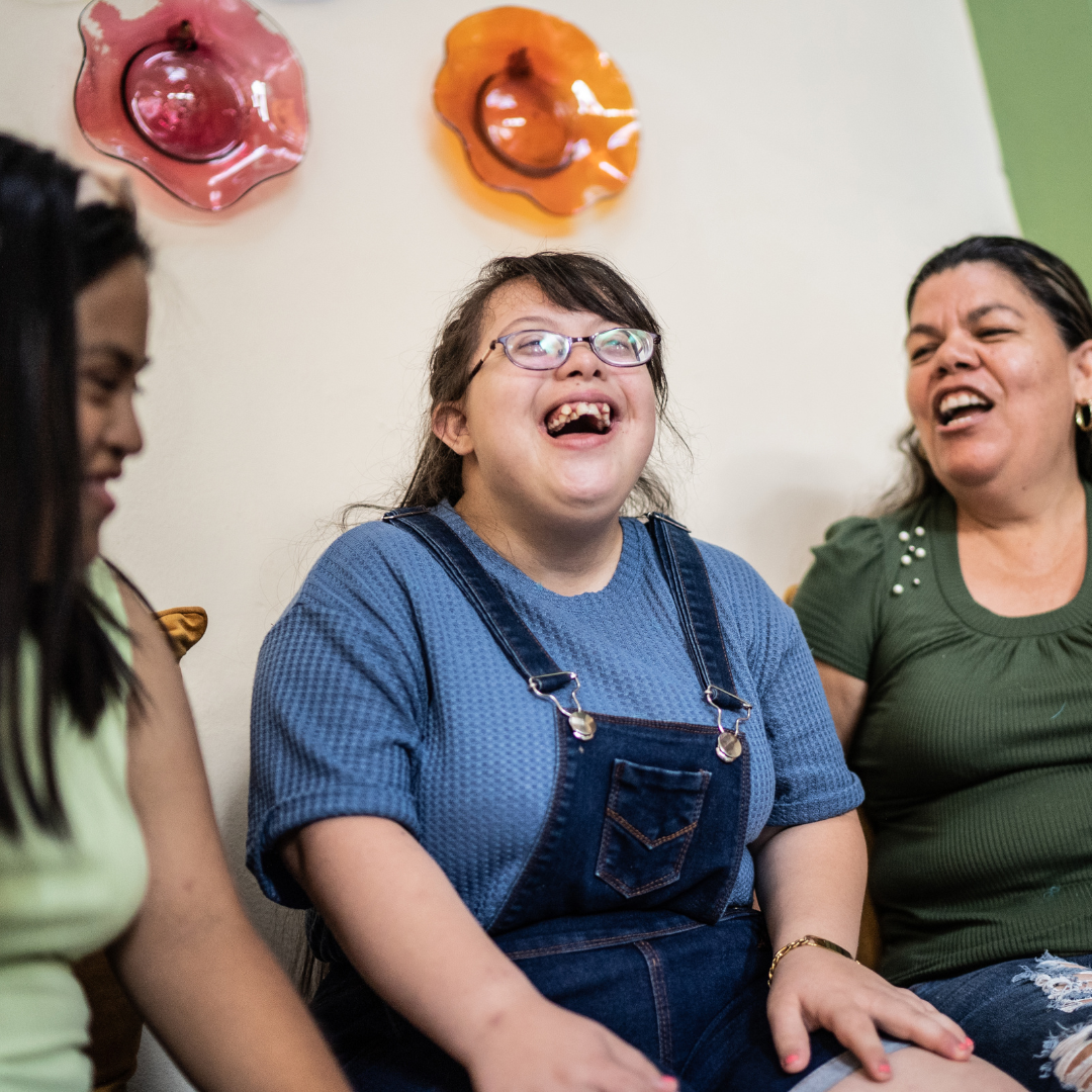 Three females sat together laughing