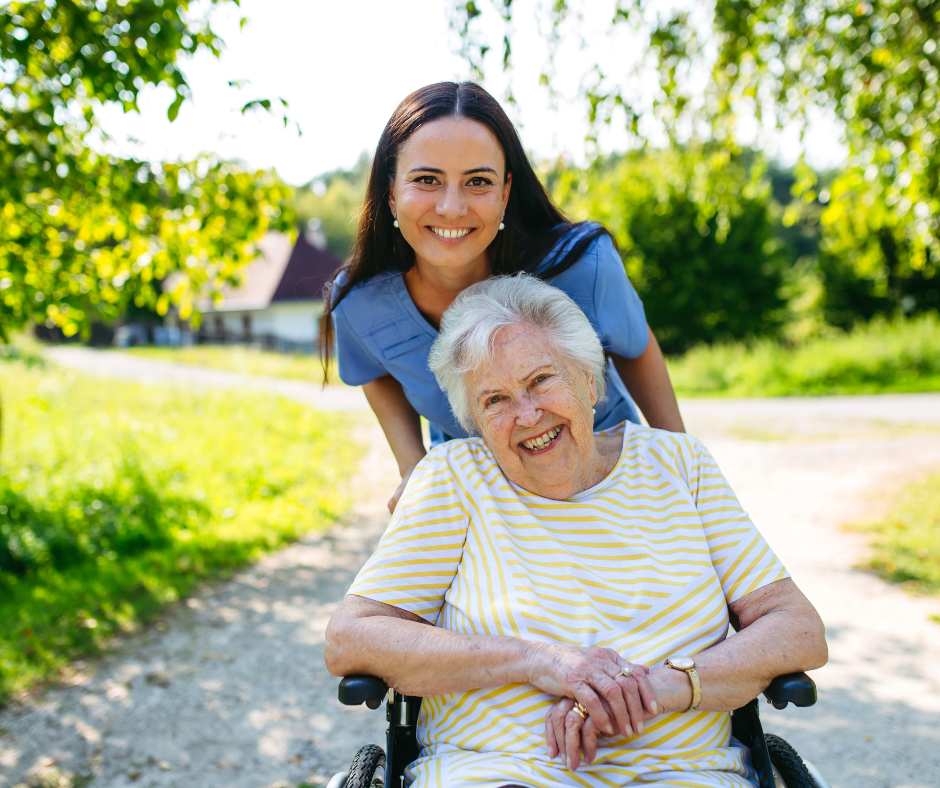A woman in a wheelchair with a carer pushing her