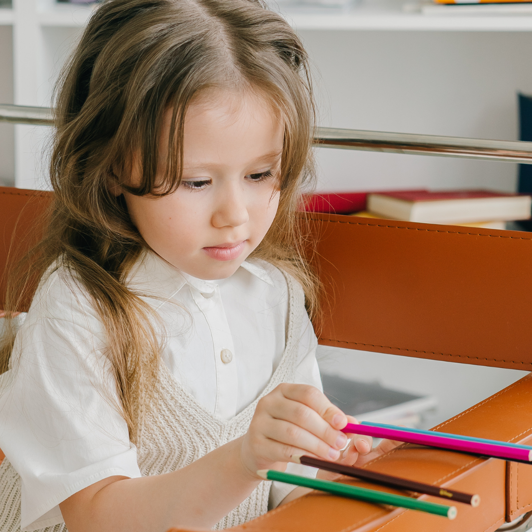 A girl lining up pencils