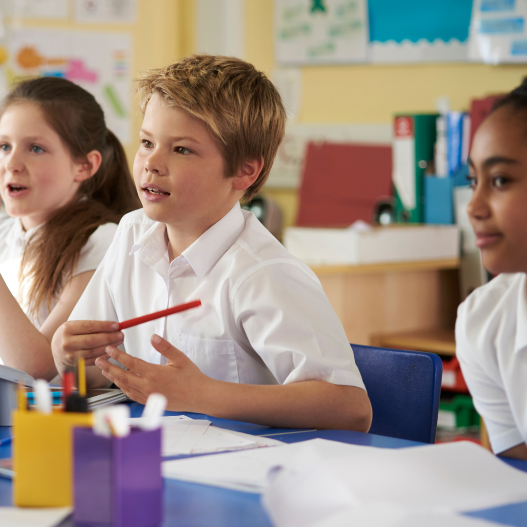 Three children in uniform sat working at table