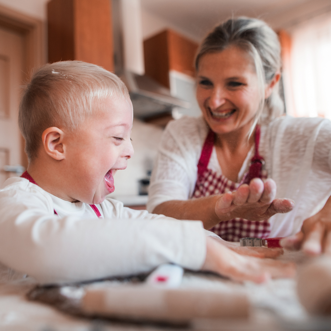 A young boy playing at a table with a woman