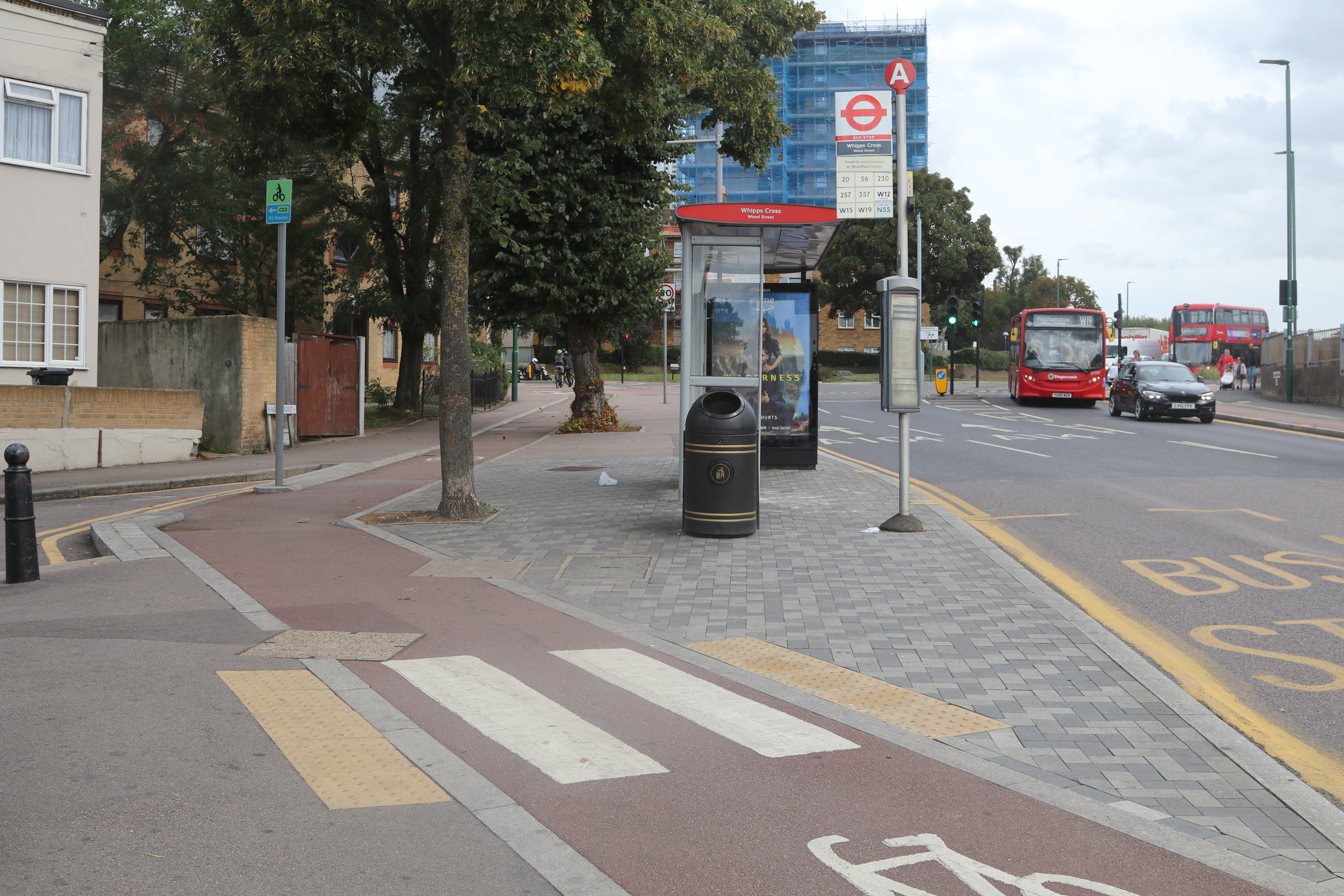 a photo of a bus stop with a cycle lane diverted behind it and a mini zebra crossing over the cycle lane