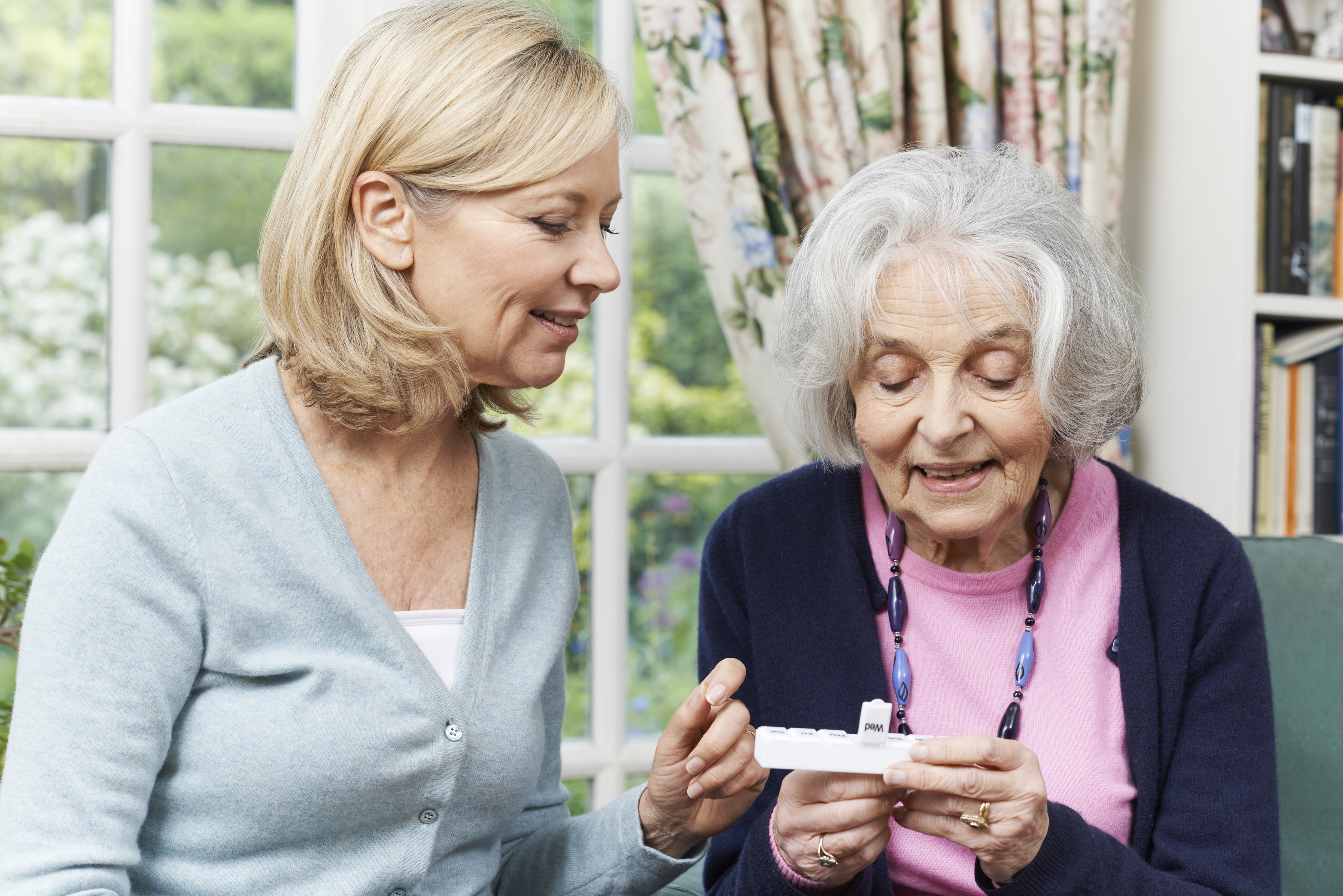 carer helping older lady with her medication