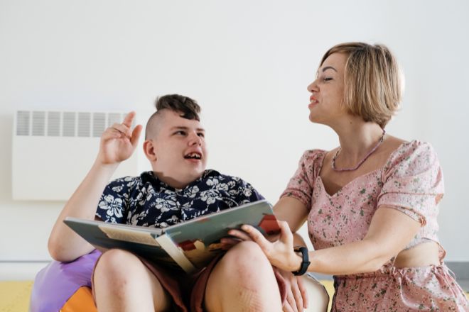Boy reading a book with adult