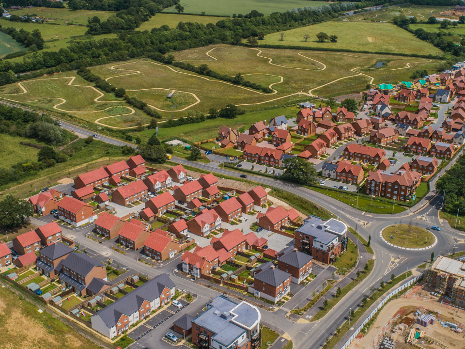 Overhead view of a new housing development with public parks in background