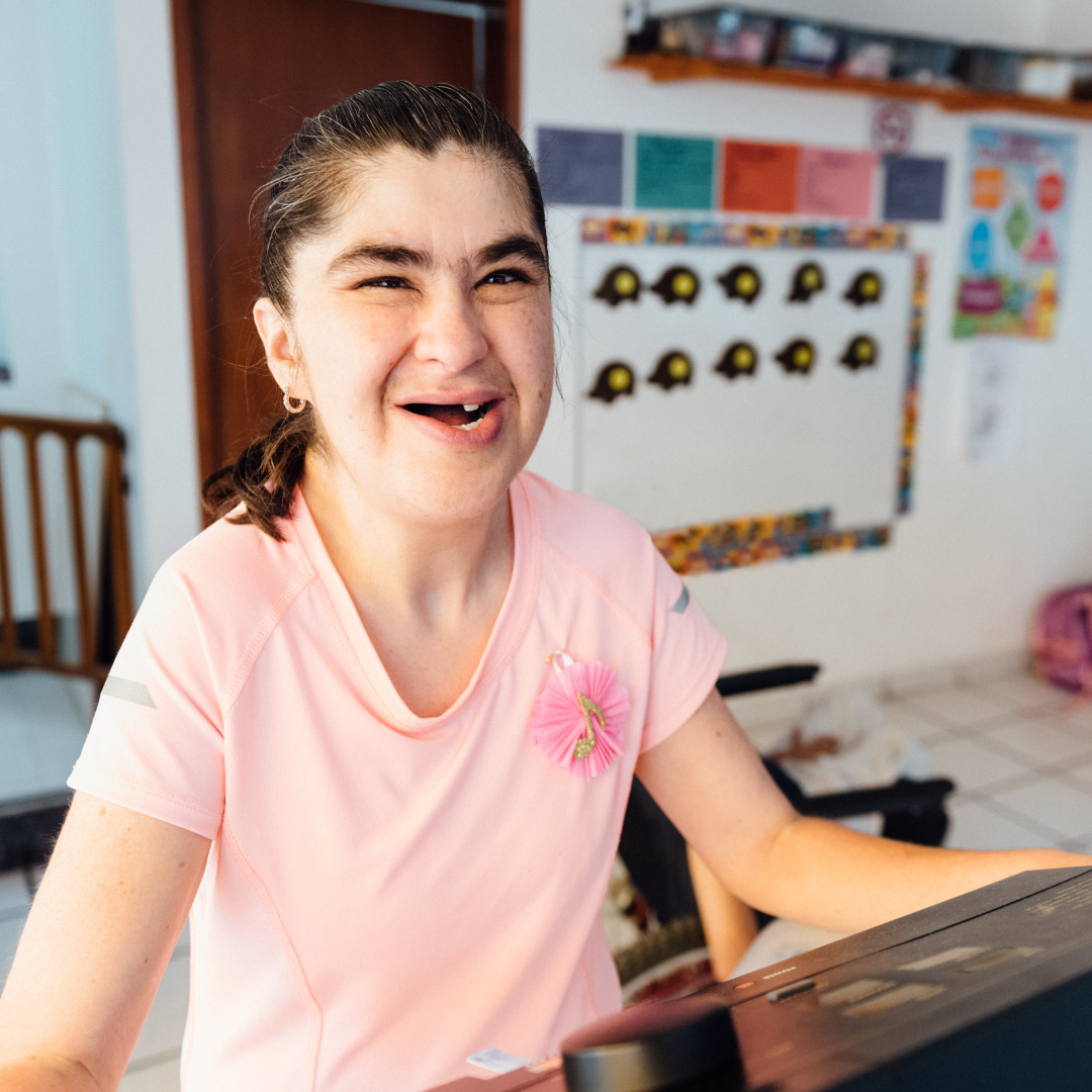 A girl in a classroom smiling at the camera