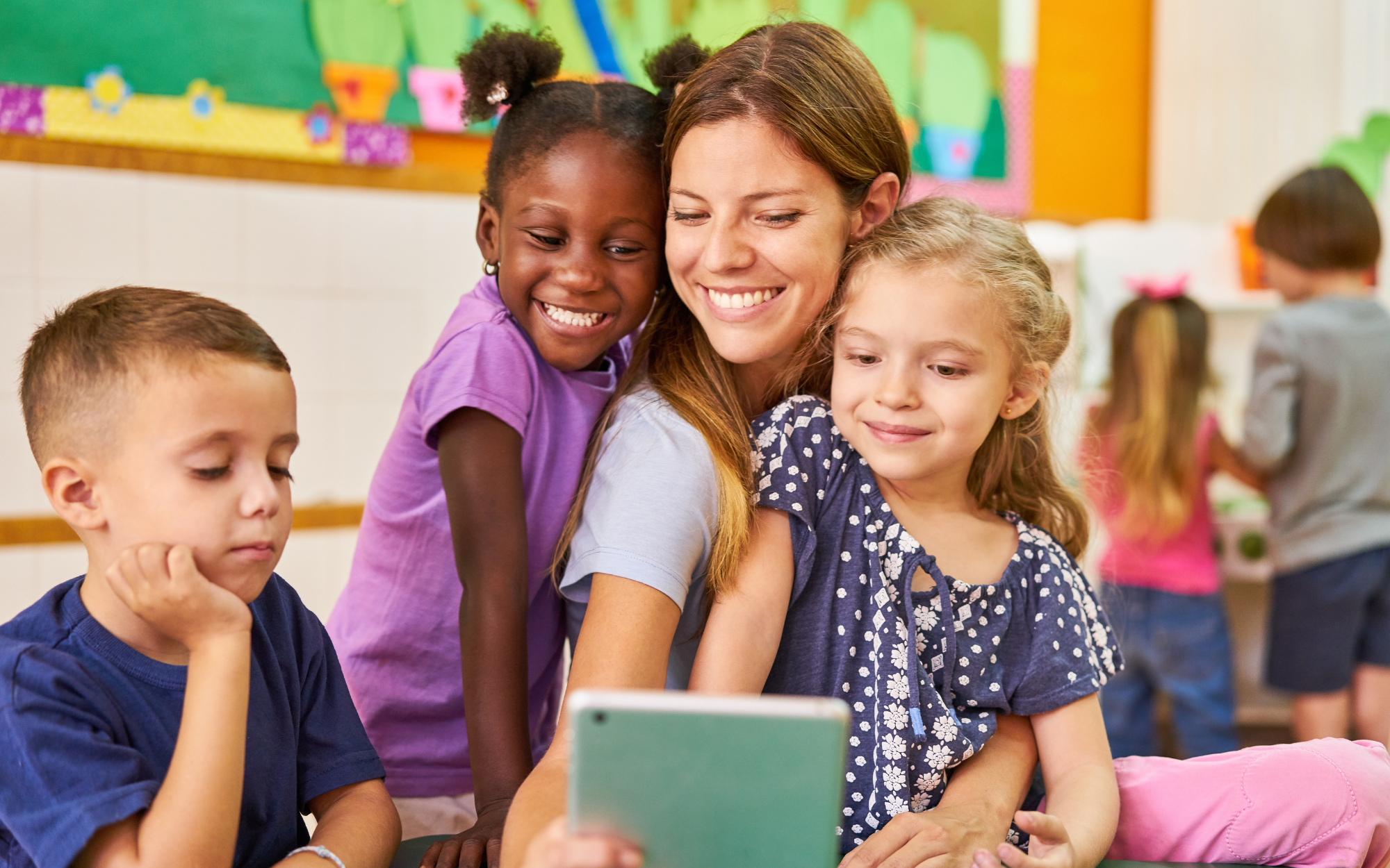 A woman with three young children reading them a book 