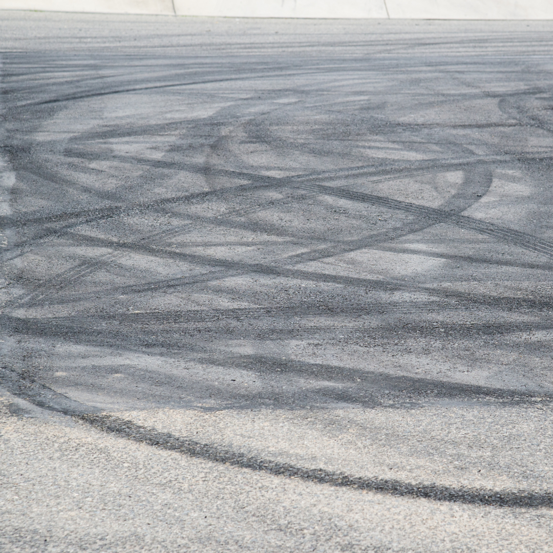 Multiple tyre tracks on tarmacked ground