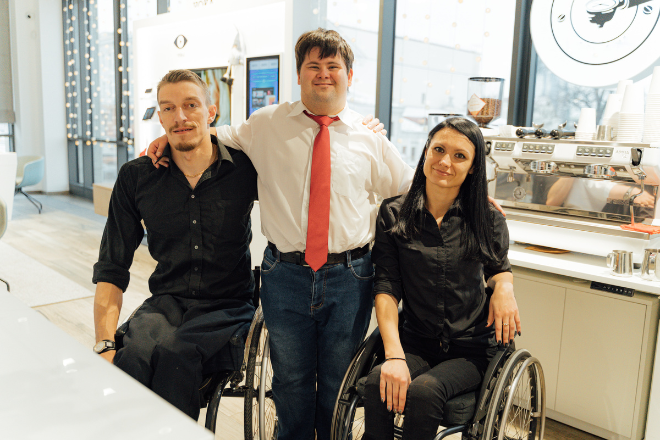 Two people in wheelchairs and one standing