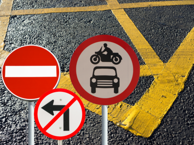 A yellow hatched area of road and other road signs (no entry, no left turn(
